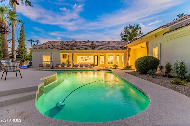 pool at dusk featuring a patio area