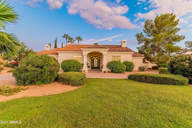 mediterranean / spanish home featuring a front lawn