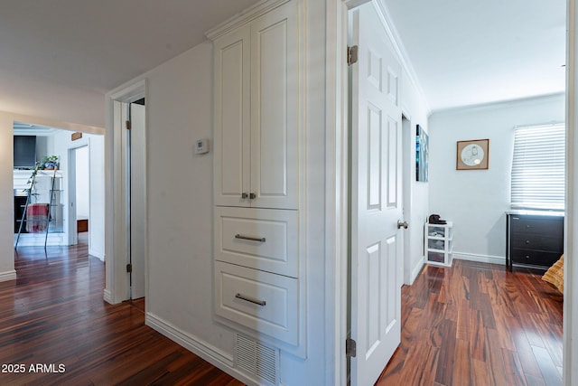 hallway featuring ornamental molding and dark hardwood / wood-style flooring