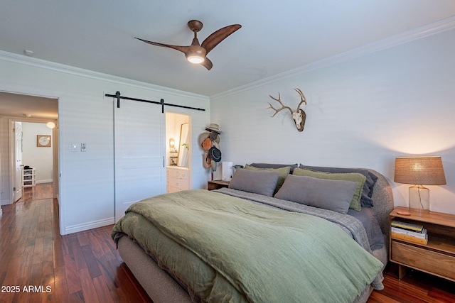 bedroom with dark wood-type flooring, ceiling fan, connected bathroom, ornamental molding, and a barn door