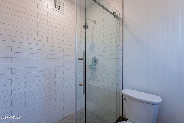 bathroom with an enclosed shower and toilet