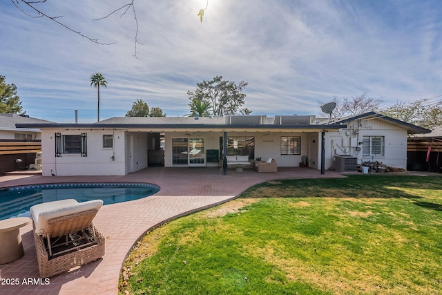 rear view of house featuring a lawn, central air condition unit, and a patio area