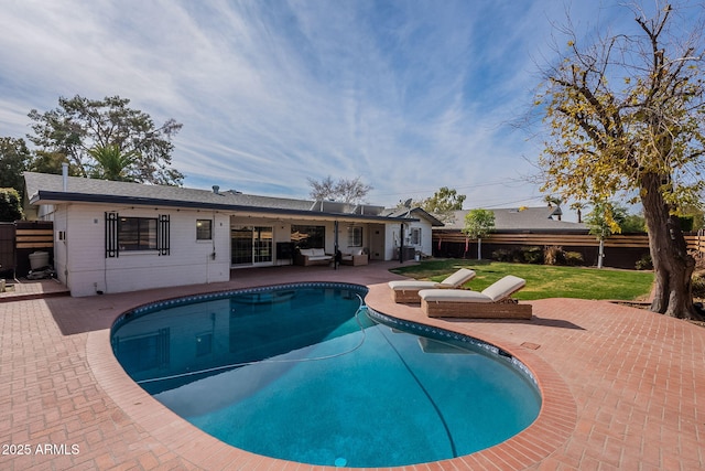 view of pool with a patio and a lawn