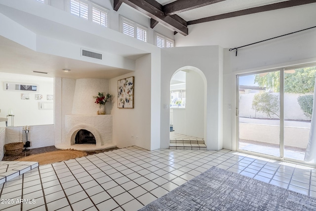 unfurnished living room with a premium fireplace, a wealth of natural light, and light tile patterned flooring