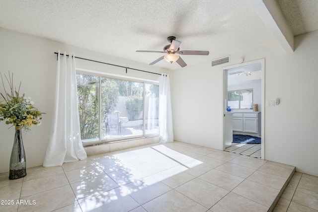 unfurnished room featuring ceiling fan, light tile patterned floors, and a textured ceiling