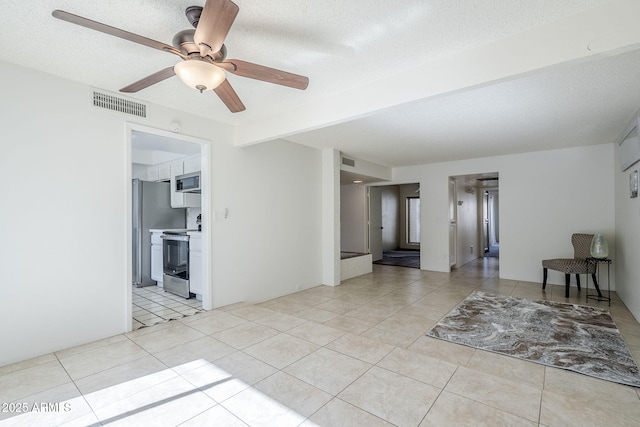 tiled empty room featuring ceiling fan, beam ceiling, and a textured ceiling