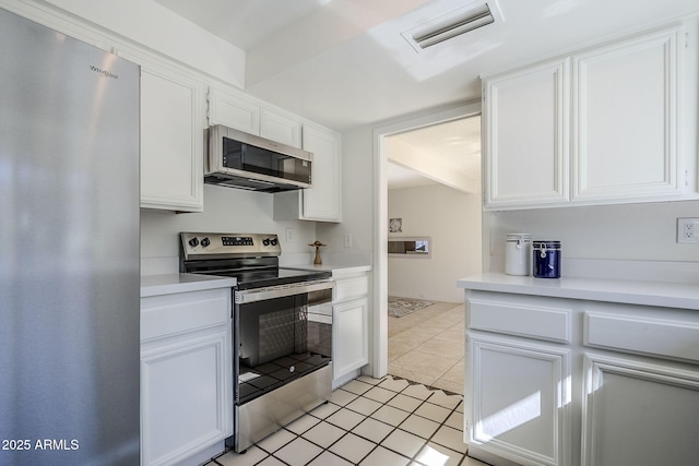 kitchen featuring light tile patterned floors, white cabinets, and appliances with stainless steel finishes