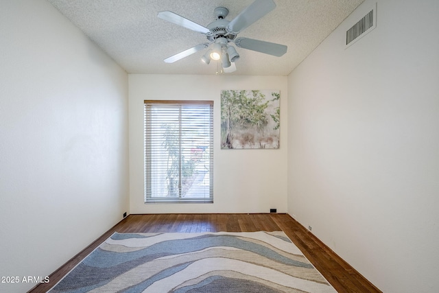 unfurnished room with ceiling fan, hardwood / wood-style floors, and a textured ceiling