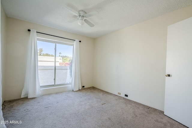 carpeted empty room featuring ceiling fan and a textured ceiling