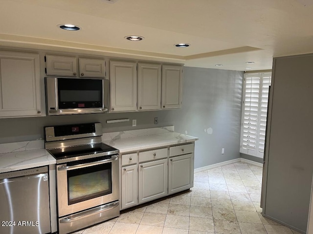 kitchen with light stone countertops and appliances with stainless steel finishes