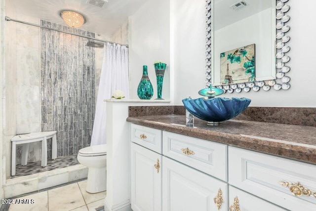 bathroom featuring tile patterned floors, toilet, vanity, and walk in shower