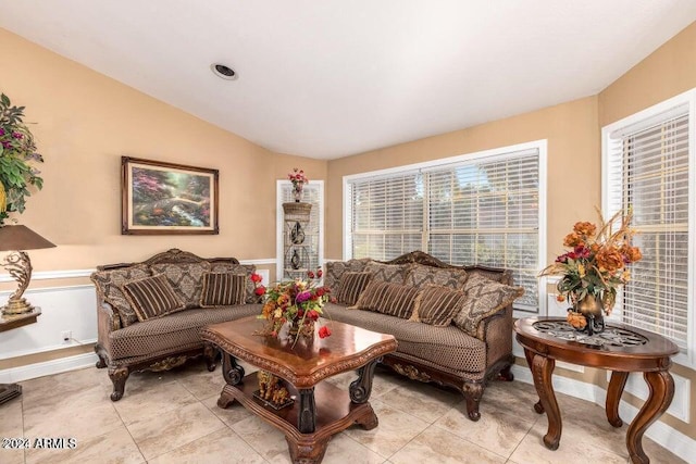 living room featuring light tile patterned floors and vaulted ceiling