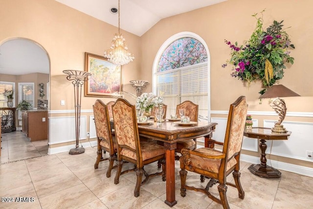 dining area featuring a chandelier, light tile patterned floors, and vaulted ceiling