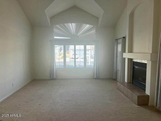 unfurnished living room with lofted ceiling, carpet flooring, and a fireplace