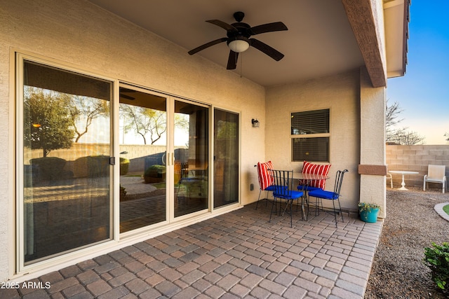 view of patio featuring ceiling fan and fence