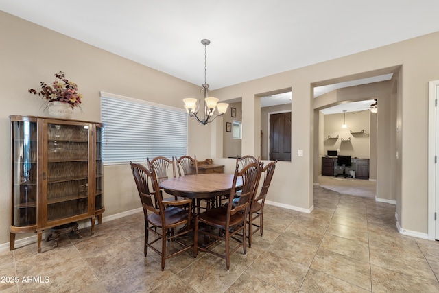 dining area featuring light tile patterned floors, baseboards, and a notable chandelier