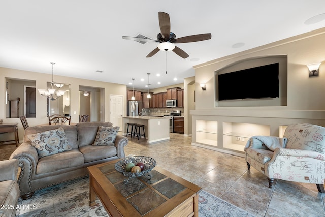 living area featuring recessed lighting and ceiling fan with notable chandelier