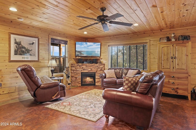 living room featuring a stone fireplace, wood ceiling, wood walls, and ceiling fan