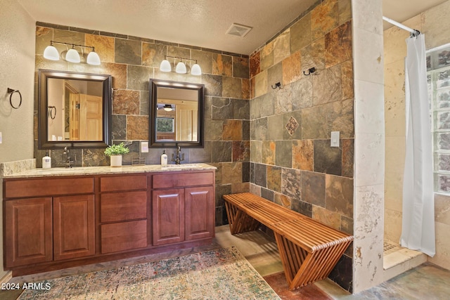 bathroom featuring vanity, tile walls, a shower with shower curtain, and a textured ceiling