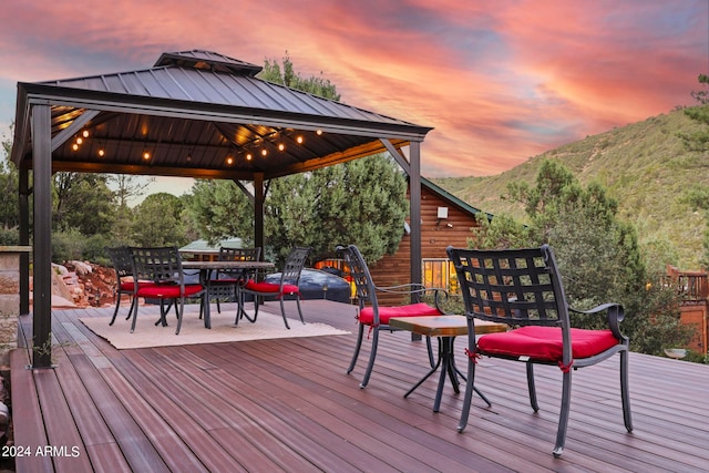 deck at dusk featuring a gazebo and a mountain view