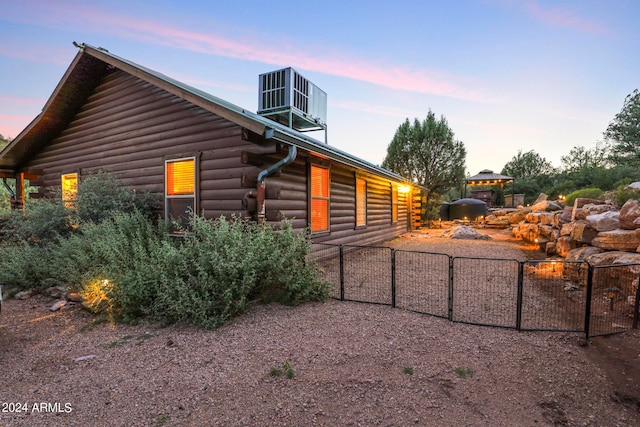 property exterior at dusk with a gazebo and central air condition unit