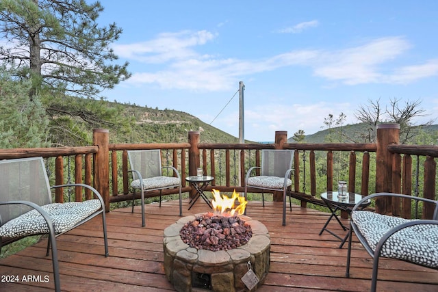 deck with a mountain view and a fire pit