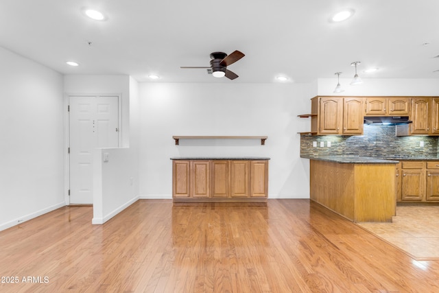 4200 N Miller Rd Unit 112, Scottsdale, AZ 85251 - kitchen with under cabinet range hood, open shelves, a ceiling fan, backsplash, and light wood-style floors