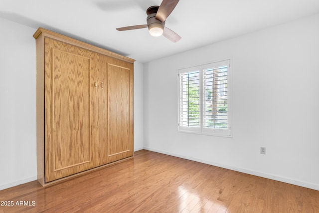 4200 N Miller Rd Unit 112, Scottsdale, AZ 85251 - unfurnished bedroom featuring wood finished floors, baseboards, and a ceiling fan