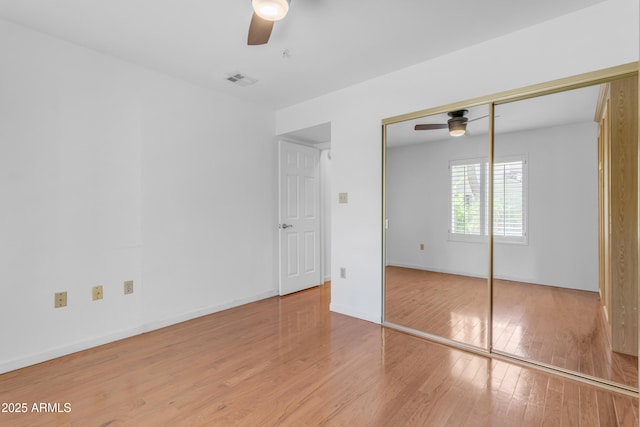 4200 N Miller Rd Unit 112, Scottsdale, AZ 85251 - unfurnished bedroom with wood finished floors, a closet, ceiling fan, and baseboards