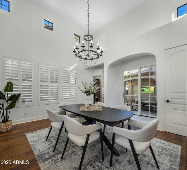 dining space featuring dark hardwood / wood-style floors and a towering ceiling