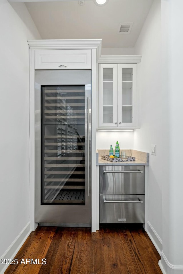 bar with dark hardwood / wood-style floors, wine cooler, and white cabinets