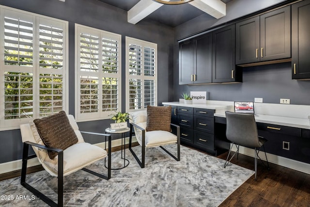 office with beam ceiling, built in desk, and dark hardwood / wood-style flooring