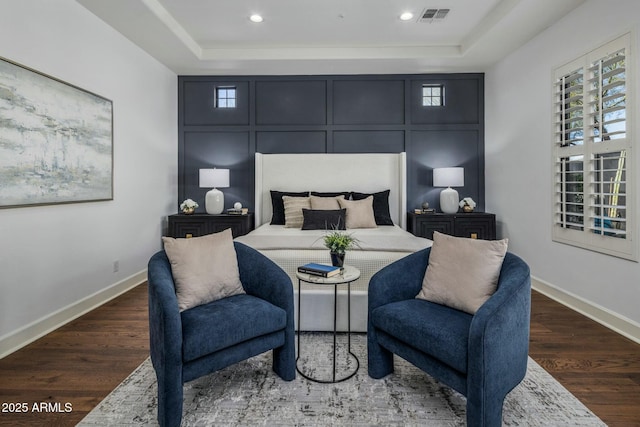 bedroom featuring dark wood-type flooring and a tray ceiling