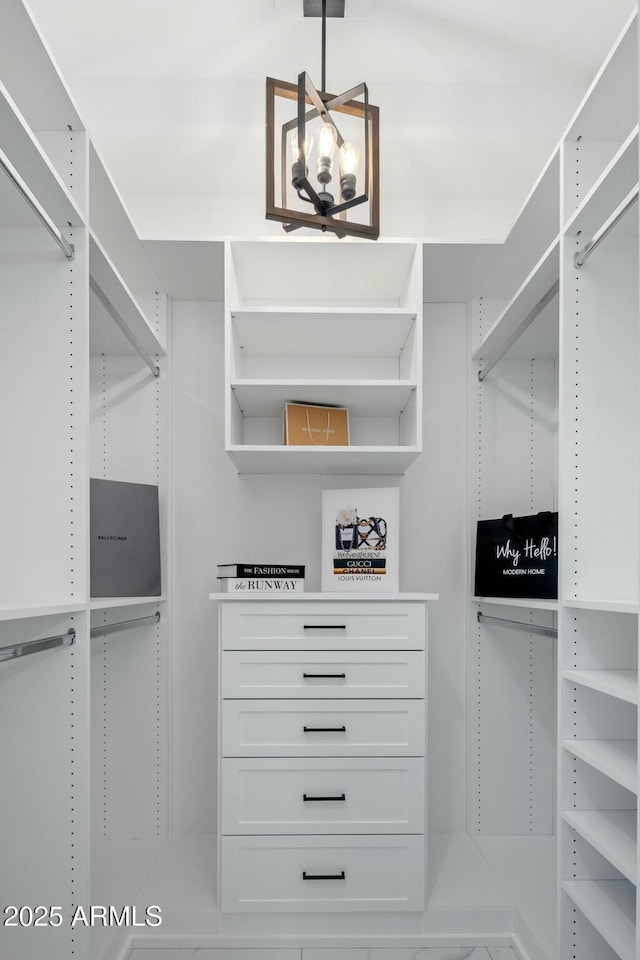 walk in closet with a chandelier