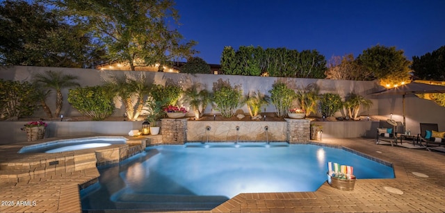 pool at twilight with an in ground hot tub