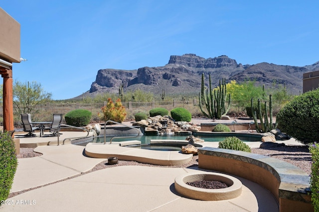 surrounding community with a fenced backyard, a swimming pool, a mountain view, and a patio