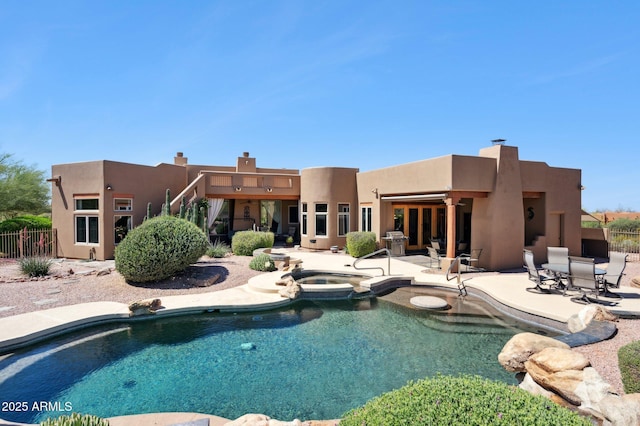 view of swimming pool with a pool with connected hot tub, fence, a patio area, and a grill