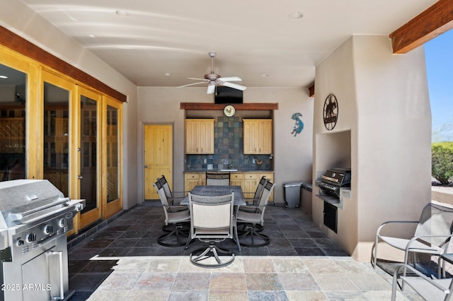 view of patio / terrace with outdoor dining area, a grill, ceiling fan, and an outdoor kitchen
