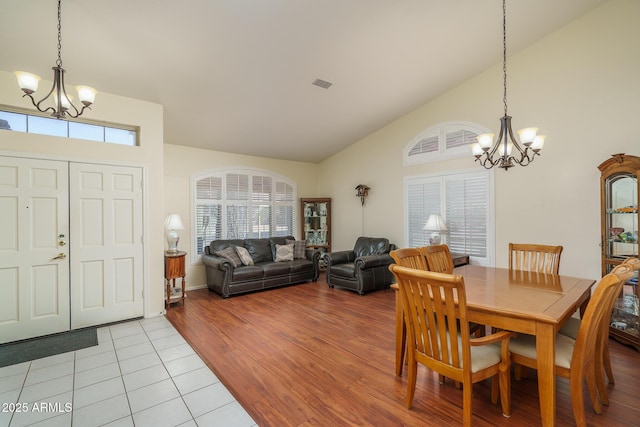 dining room with light tile patterned floors, a healthy amount of sunlight, and a notable chandelier