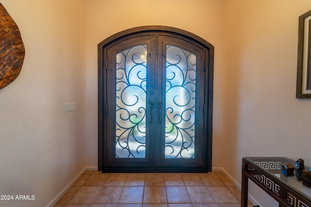 foyer featuring french doors, light tile patterned floors, and a wealth of natural light