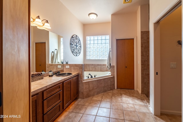 bathroom with vanity, a relaxing tiled tub, and tile patterned floors