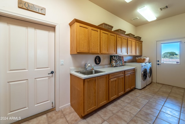 washroom featuring cabinets, light tile patterned floors, washer and clothes dryer, and sink