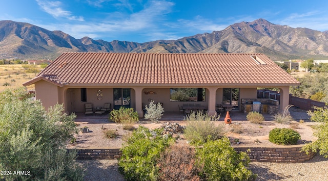 rear view of property with a mountain view and a patio