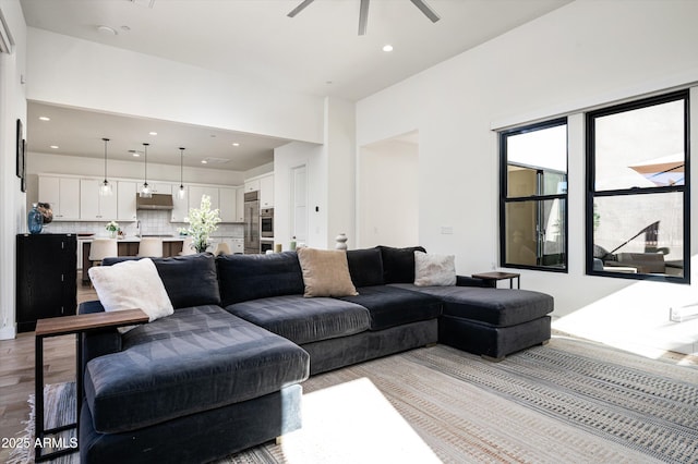 living room with ceiling fan and light wood-type flooring