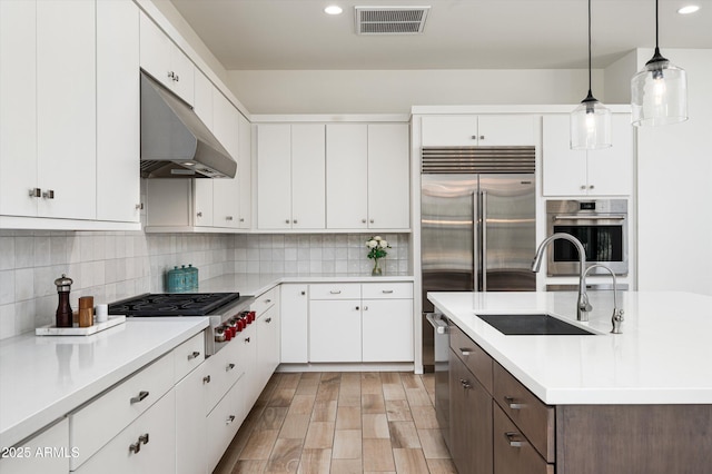 kitchen with appliances with stainless steel finishes, sink, and white cabinets