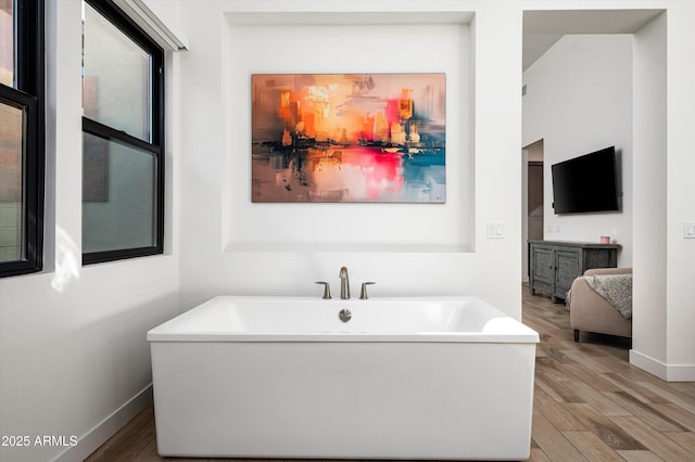 bathroom with wood-type flooring and a washtub