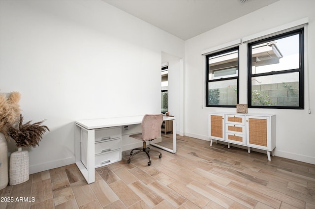 home office with light hardwood / wood-style floors