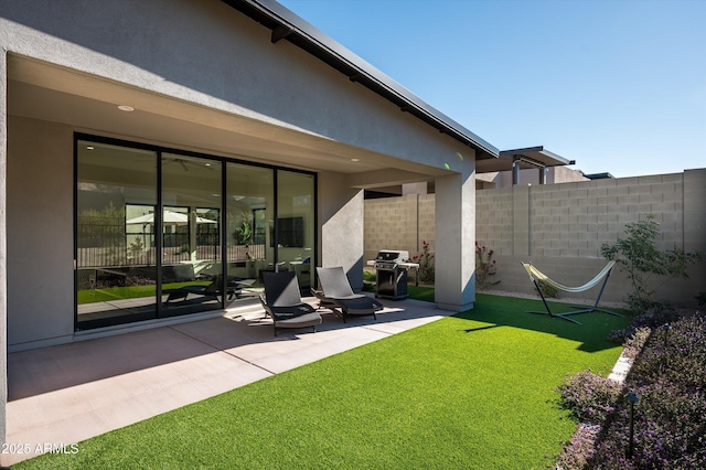 rear view of house featuring a yard and a patio area