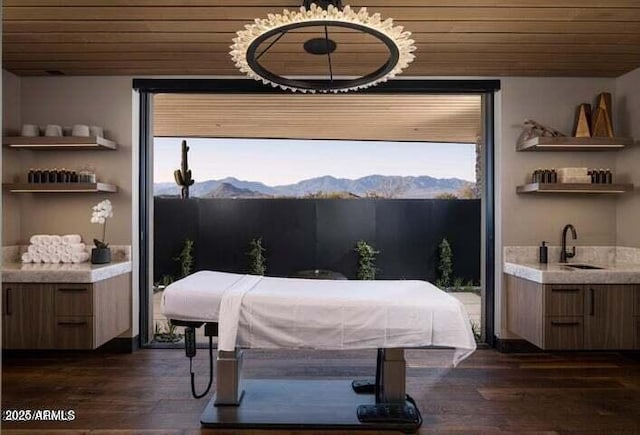 interior space with a mountain view, dark hardwood / wood-style floors, wooden ceiling, and sink