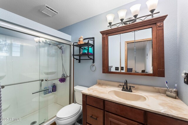 bathroom featuring a stall shower, visible vents, vanity, and toilet